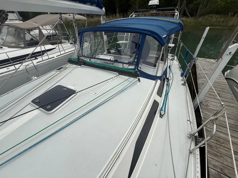 Slide: The Image of 2001 Catalina 42 MkII sailboat docked, featuring a blue canopy and sleek deck design. - 11