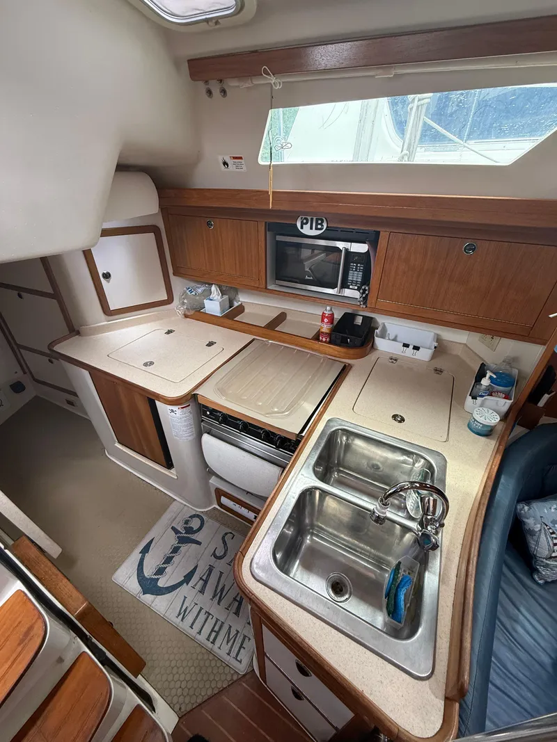 Slide: The Image of Interior of 2001 Catalina 42 MkII sailboat featuring a compact kitchen area. - 26