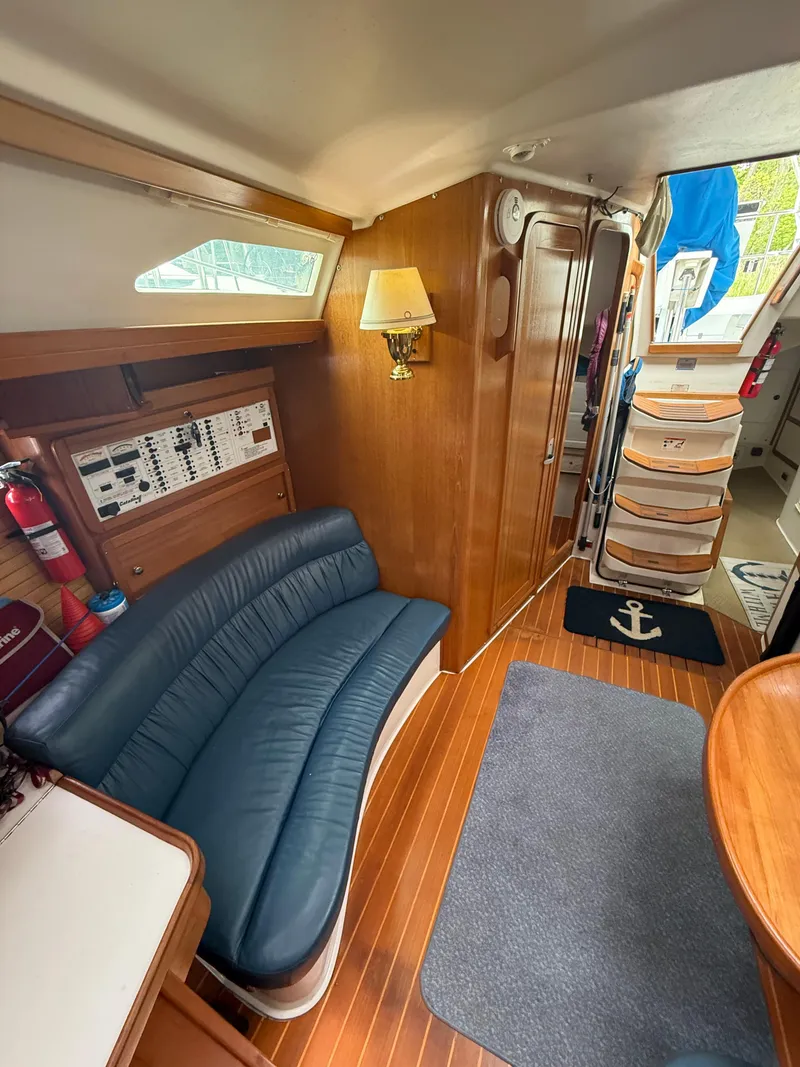 Slide: The Image of Interior of 2001 Catalina 42 MkII sailboat with blue seating and wooden accents. - 29