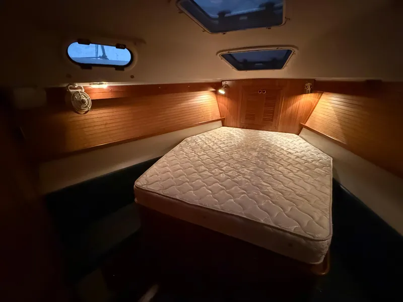 Slide: The Image of Cozy cabin interior of 2001 Catalina 42 MkII sailboat with mattress and warm lighting. - 34