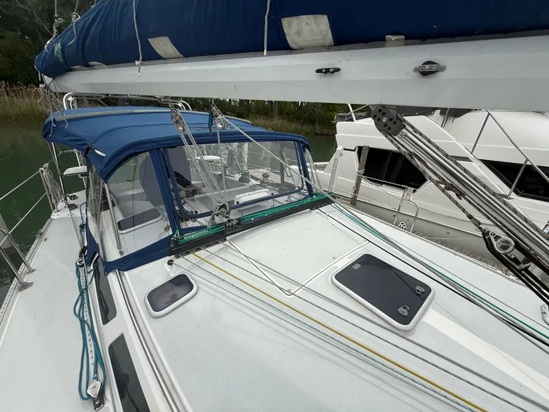 Slide: The Image of 2001 Catalina 42 MkII sailboat with blue canopy and rigging, docked in a marina. - 9