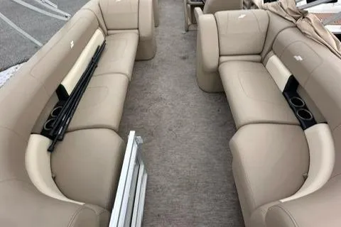 Slide: The Image of 2021 Starcraft LX 22 R boat interior with beige seating and cup holders. - 2