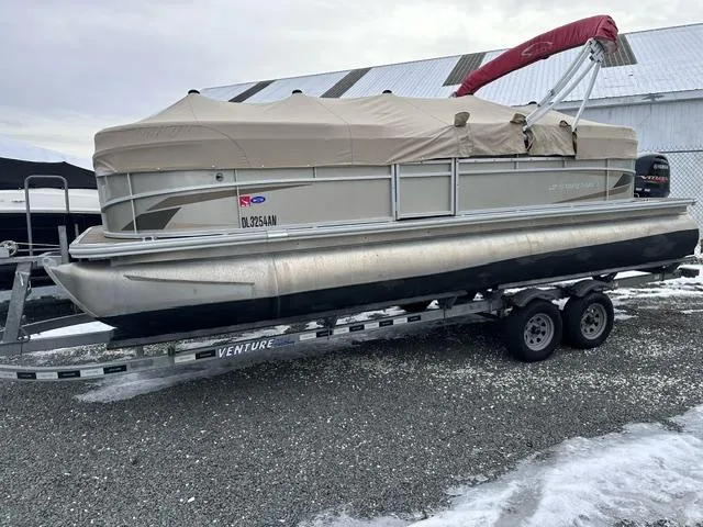 Slide: The Image of 2021 Starcraft LX 22 R pontoon boat on trailer, covered and parked on snowy ground. - 6