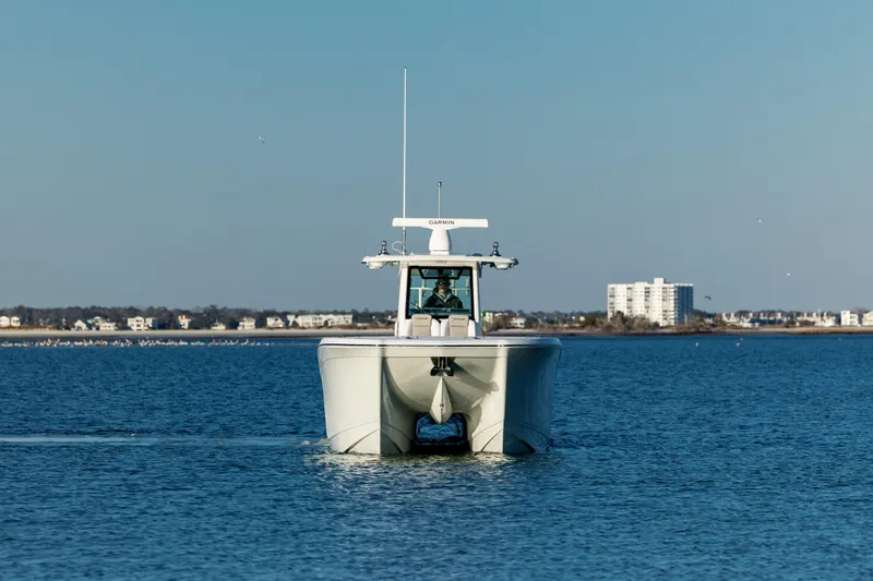 Slide: The Image of 2025 Caymas 34 CT boat cruising on open water, distant shoreline in background. - 1