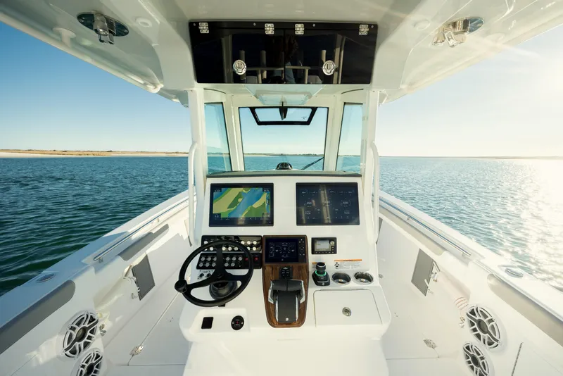 Slide: The Image of 2025 Caymas 34 CT boat cockpit with advanced navigation system on open water. - 17