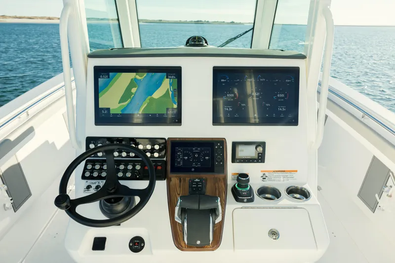 Slide: The Image of Helm of 2025 Caymas 34 CT boat with advanced navigation displays and controls. - 18