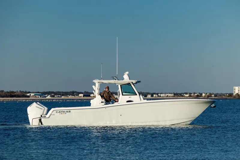 Slide: The Image of 2025 Caymas 34 CT boat cruising on calm water under clear blue sky. - 2