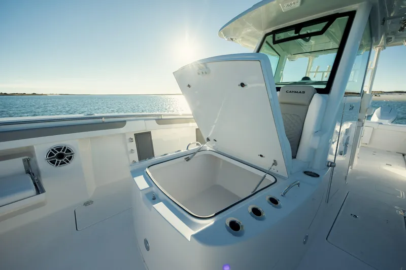 Slide: The Image of 2025 Caymas 34 CT boat interior with open storage compartment, sunlit ocean backdrop. - 22