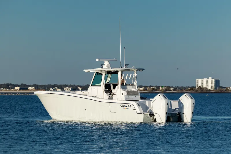 Slide: The Image of 2025 Caymas 34 CT boat on calm water, distant shoreline in background. - 6