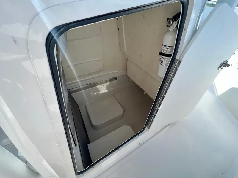 Slide: The Image of 2023 Bayliner Trophy 24 CC storage compartment with fire extinguisher. - 14