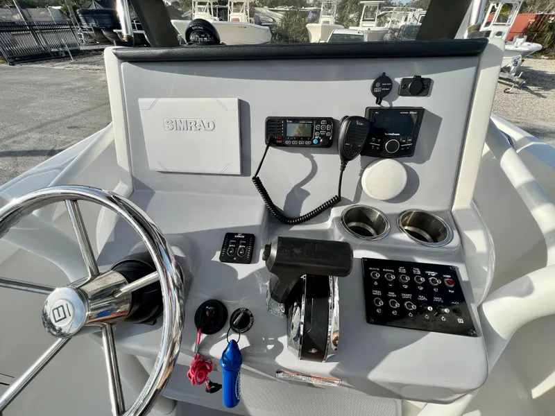 Slide: The Image of 2023 Bayliner Trophy 24 CC helm with steering wheel, controls, and electronics. - 16