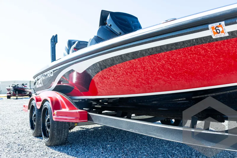 Slide: The Image of 2017 Nitro Z21 Z-PRO Package boat, red and black, parked on gravel. - 12
