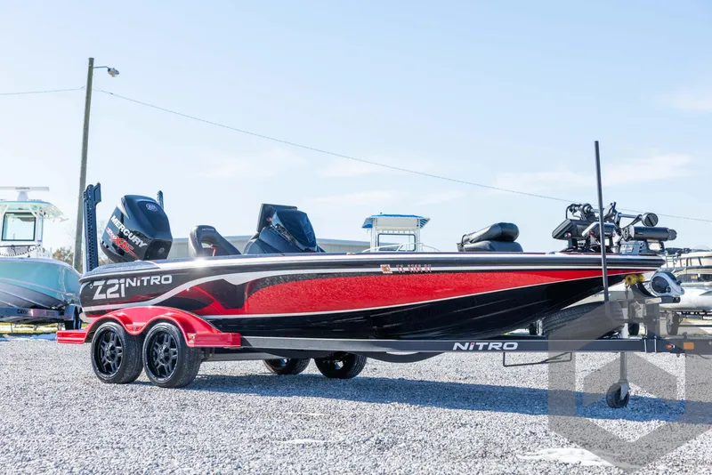 Slide: The Image of 2017 Nitro Z21 Z-PRO Package boat, red and black, parked on gravel. - 3