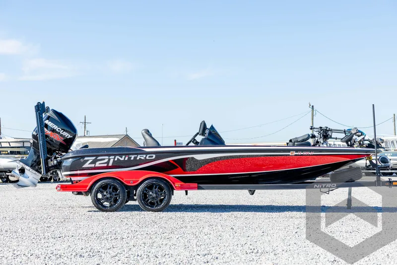Slide: The Image of 2017 Nitro Z21 Z-PRO Package boat, red and black, parked on gravel. - 4