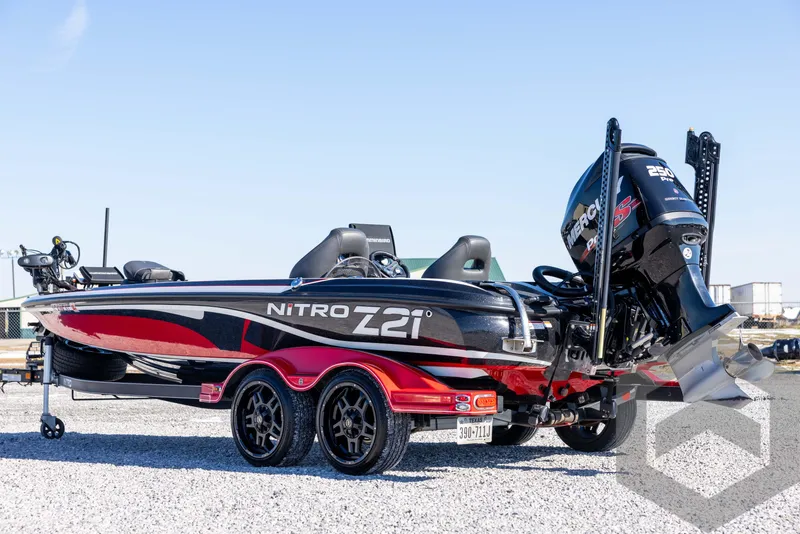 Slide: The Image of 2017 Nitro Z21 Z-PRO Package boat with dual axle trailer, parked on gravel. - 7