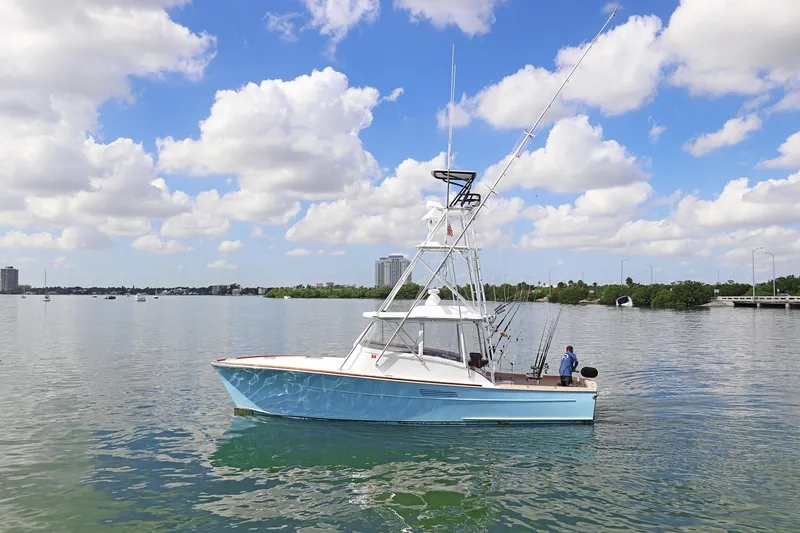 Slide: The Image of 1997 Gamefisherman 34 Express boat on calm water under a partly cloudy sky. - 0