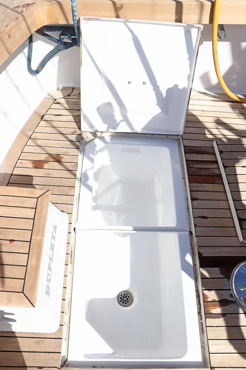 Slide: The Image of 1997 Gamefisherman 34 Express boat deck with open storage compartment and wooden flooring. - 10