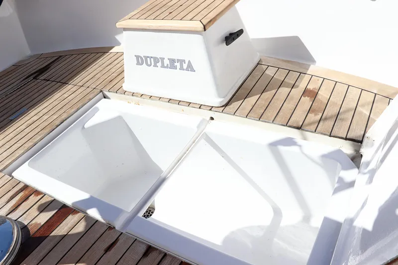 Slide: The Image of 1997 Gamefisherman 34 Express boat deck with wooden flooring and storage compartment. - 11