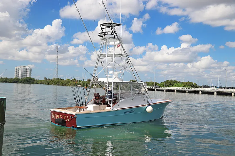 Slide: The Image of 1997 Gamefisherman 34 Express boat on calm water under a partly cloudy sky. - 2