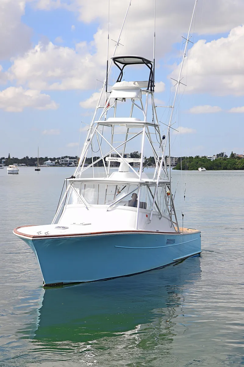 Slide: The Image of 1997 Gamefisherman 34 Express boat on calm water under a partly cloudy sky. - 3