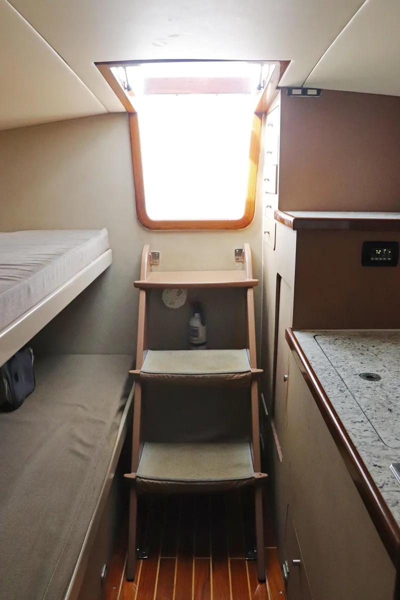Slide: The Image of Interior of 1997 Gamefisherman 34 Express boat, featuring bunk bed and wooden steps. - 30