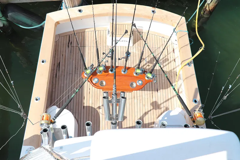 Slide: The Image of 1997 Gamefisherman 34 Express fishing boat deck with rods and wooden flooring. - 34