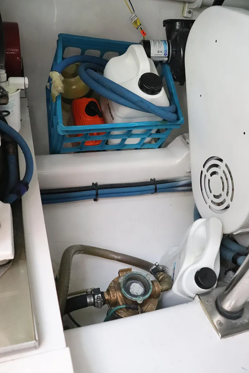 Slide: The Image of Engine compartment of 1997 Gamefisherman 34 Express with storage basket and maintenance supplies. - 38