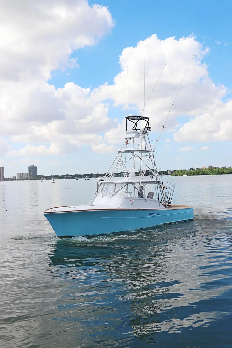 Slide: The Image of 1997 Gamefisherman 34 Express boat on calm water under a partly cloudy sky. - 4