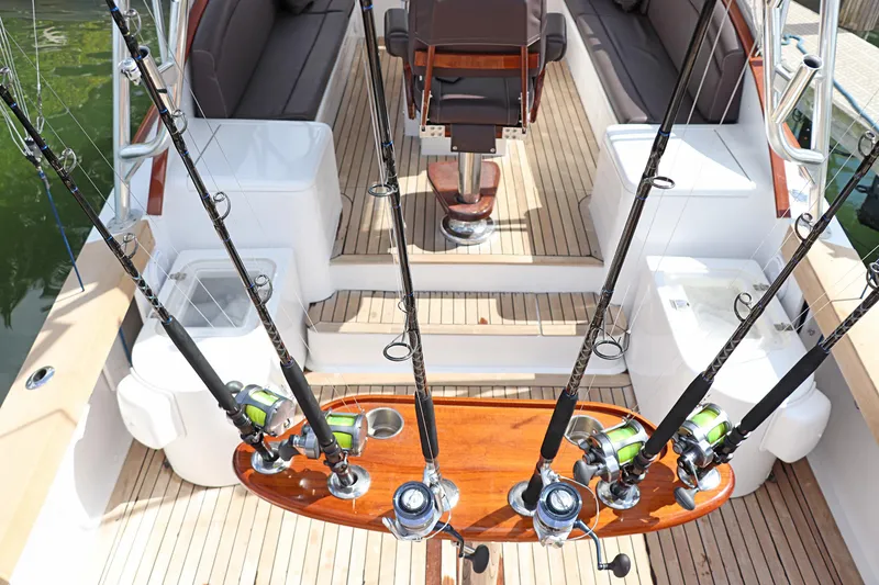 Slide: The Image of 1997 Gamefisherman 34 Express boat interior with fishing rods and wooden deck. - 47