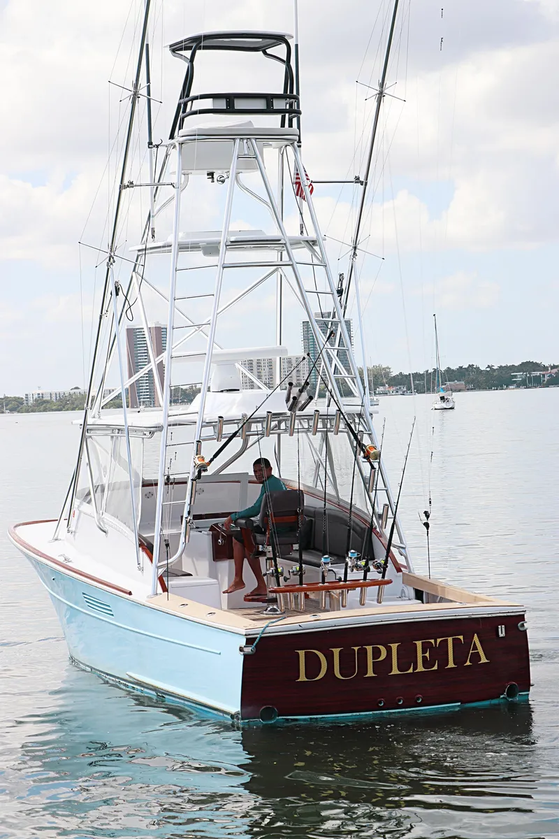 Slide: The Image of 1997 Gamefisherman 34 Express boat "DUPLETA" on calm water, featuring a tall fishing tower. - 6