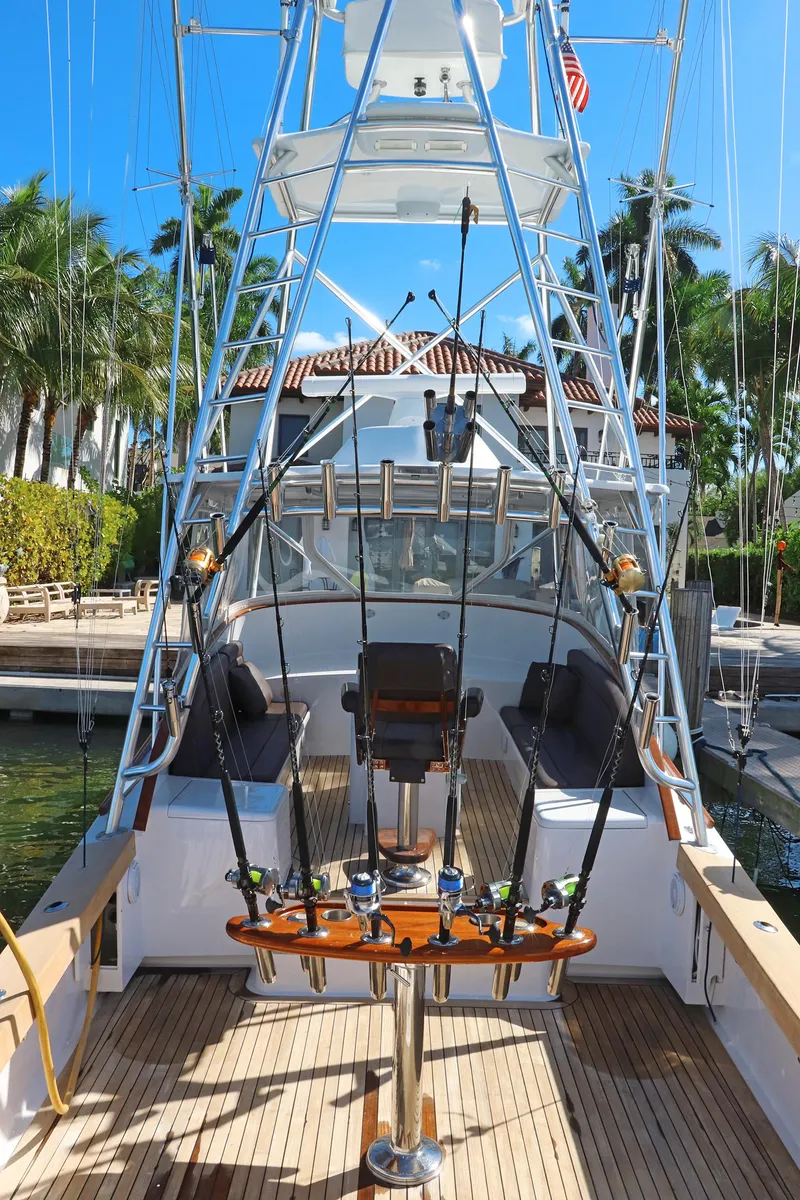 Slide: The Image of 1997 Gamefisherman 34 Express boat with fishing rods, docked near palm trees. - 8