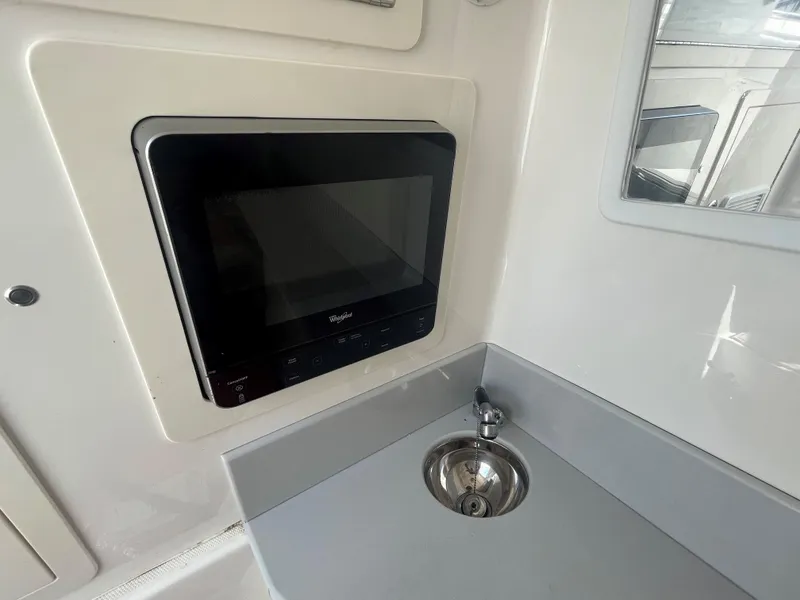 Slide: The Image of Compact kitchen area in a 2018 Blackwater 43 boat with microwave and sink. - 17