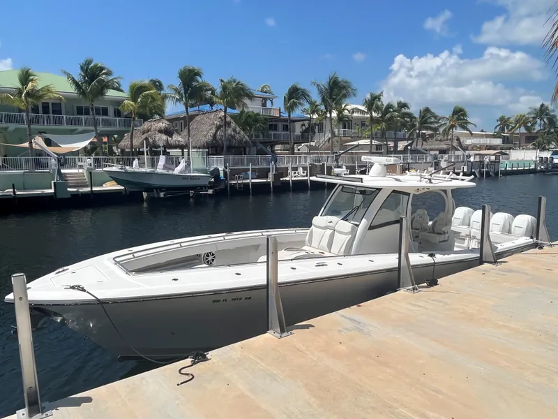 Slide: The Image of 2018 Blackwater 43 boat docked by palm trees and waterfront homes. - 2
