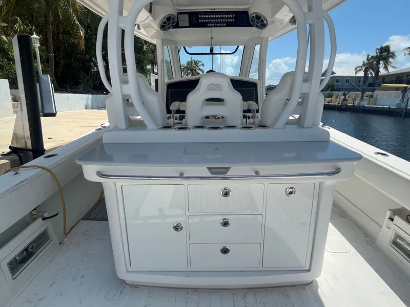 Slide: The Image of 2018 Blackwater 43 boat interior with white cabinetry and seating, docked by a canal. - 35