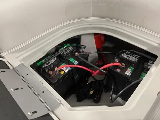 Slide: The Image of 2022 Sweetwater 2286SBCX boat battery compartment with dual batteries and wiring. - 11