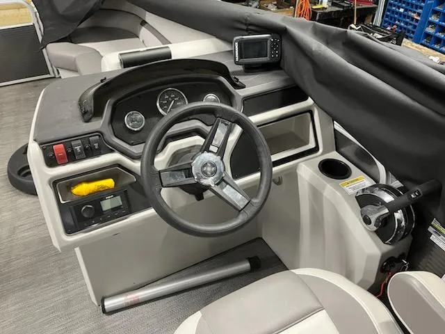 Slide: The Image of 2022 Sweetwater 2286SBCX boat dashboard with steering wheel and controls. - 5