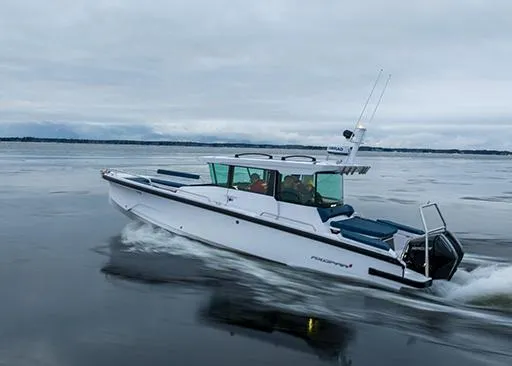 Slide: The Image of 2025 Axopar 29 Cross Cabin cruising on calm waters under cloudy skies. - 4