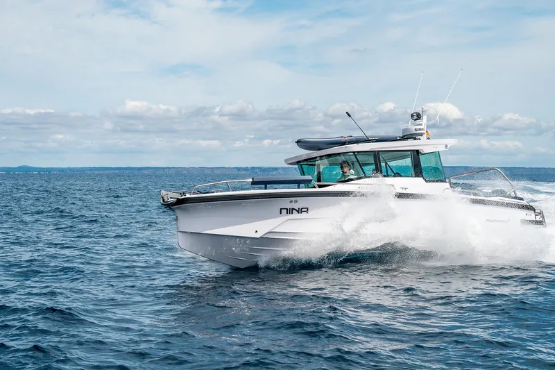 Slide: The Image of 2025 Axopar 29 Cross Cabin boat cruising on open water. - 6