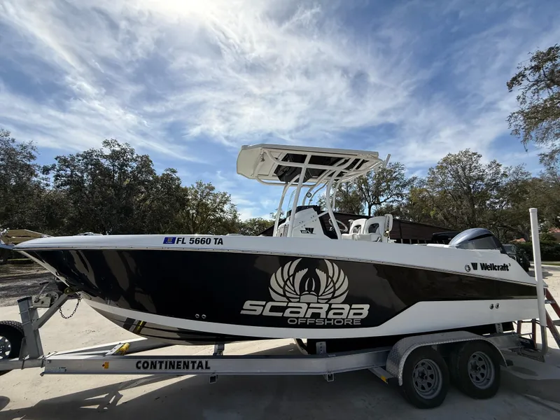 Slide: The Image of 2021 Wellcraft 242 Offshore boat on trailer under blue sky. - 1