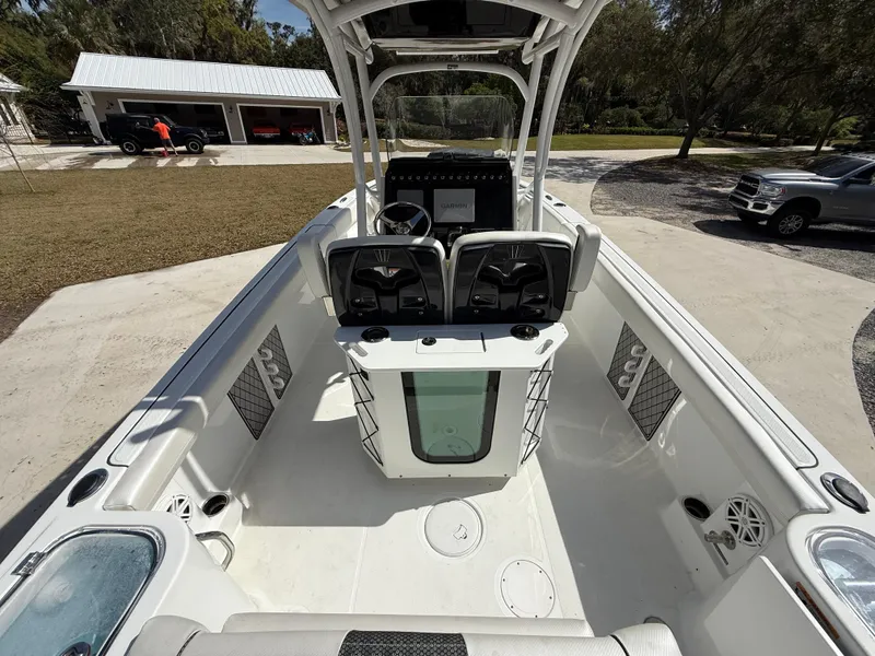 Slide: The Image of 2021 Wellcraft 242 Offshore boat interior with seating and console, parked outdoors. - 10