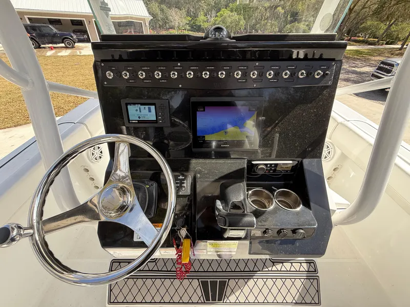 Slide: The Image of 2021 Wellcraft 242 Offshore boat dashboard with steering wheel and navigation controls. - 17