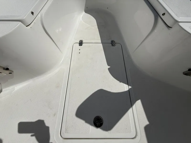 Slide: The Image of 2021 Wellcraft 242 Offshore boat interior, featuring a clean, white deck with storage hatch. - 25