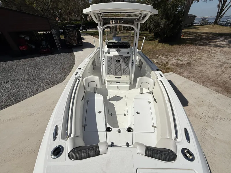 Slide: The Image of 2021 Wellcraft 242 Offshore boat, spacious deck, white interior, parked outdoors. - 37