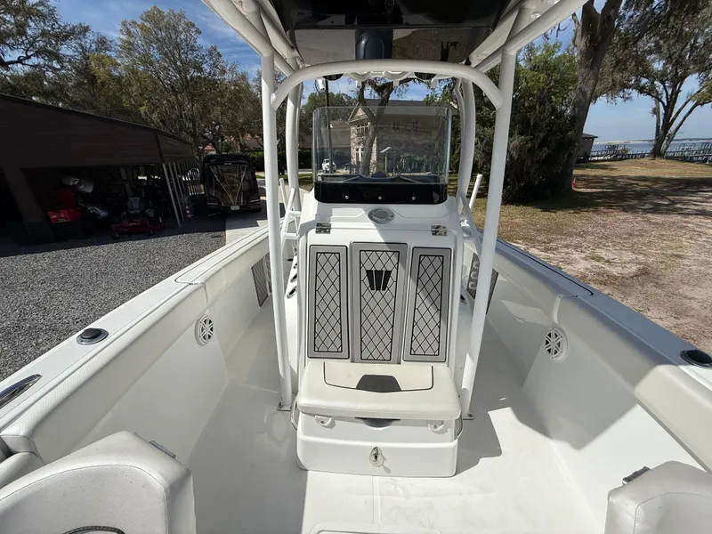 Slide: The Image of 2021 Wellcraft 242 Offshore boat interior with console, white seating, and outdoor setting. - 41