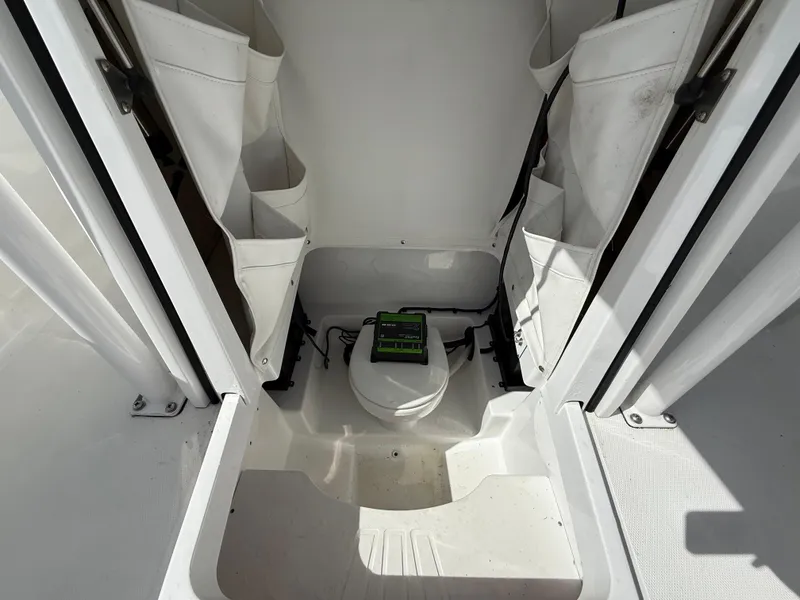 Slide: The Image of 2021 Wellcraft 242 Offshore boat interior with storage compartments and a portable toilet. - 45