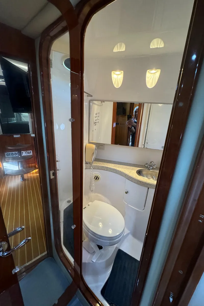 Slide: The Image of 2008 Regal Commodore 4460 yacht bathroom with modern fixtures and elegant wood accents. - 16