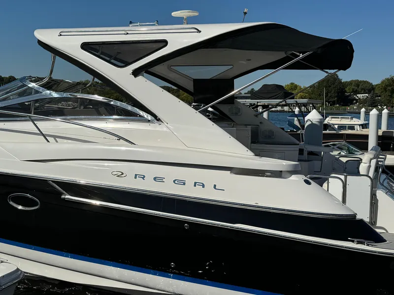 Slide: The Image of 2008 Regal Commodore 4460 yacht docked at marina, sleek design, white and black exterior. - 2