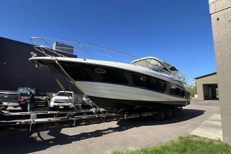 Slide: The Image of 2008 Regal Commodore 4460 yacht on trailer, parked outdoors under clear blue sky. - 22