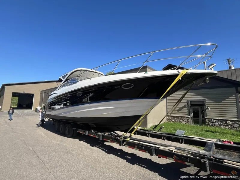 Slide: The Image of 2008 Regal Commodore 4460 yacht on trailer outside a building under clear blue sky. - 23