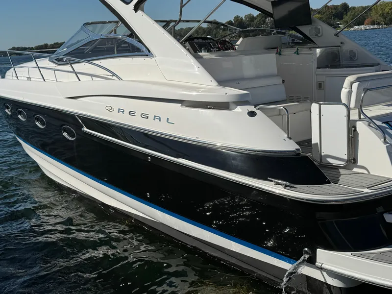 Slide: The Image of 2008 Regal Commodore 4460 yacht on water, sleek design, black and white exterior. - 3